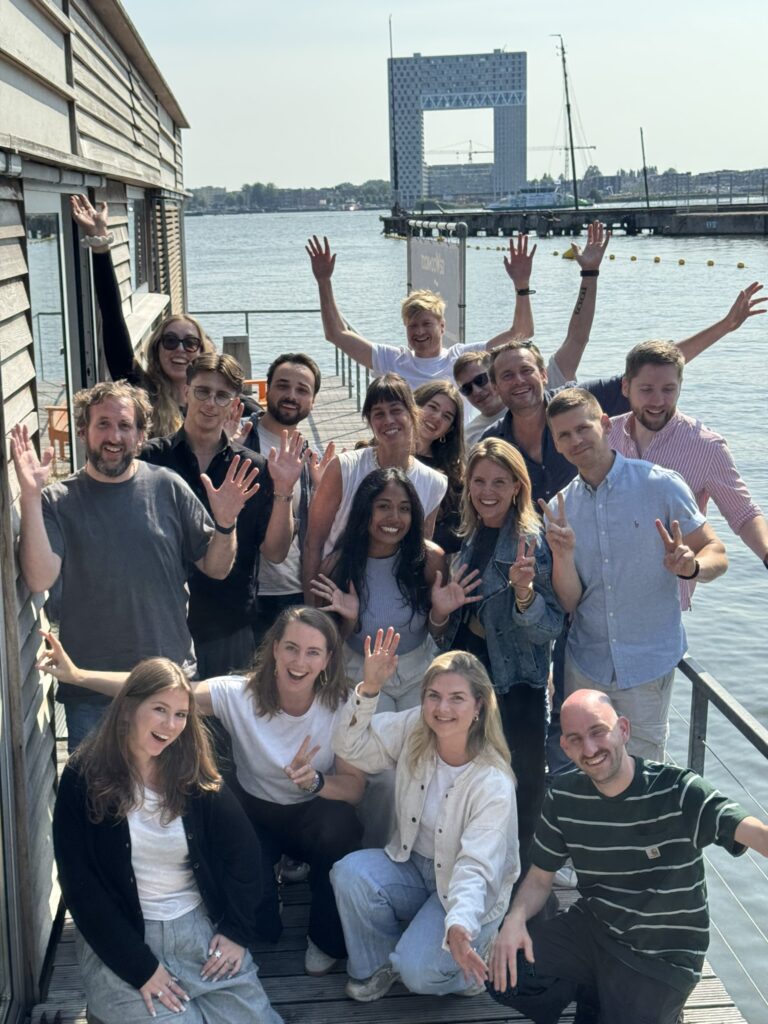 A group of people cheering next to the water.
